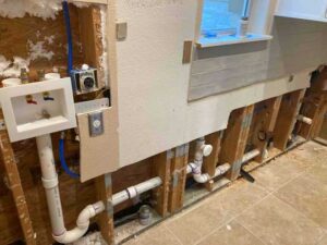 Interior plumbing repipe behind laundry area wall in Dripping Springs home