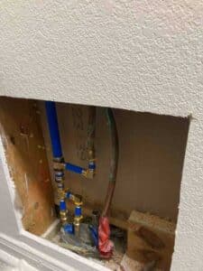 Updated water heater plumbing connections with PEX piping and shutoff valves