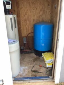 The Novo water softener system and tank in the water closet of a home