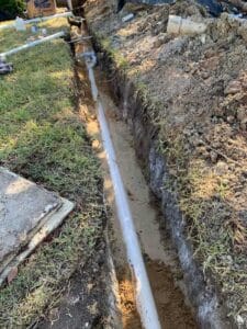 New PVC pipe installed in plumbing trench line